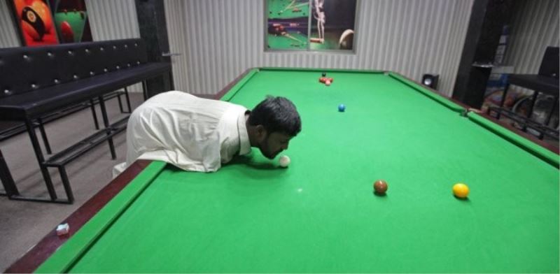 Kolları olmayan adam çenesiyle bilardo oynayarak hünerlerini sergiliyor
