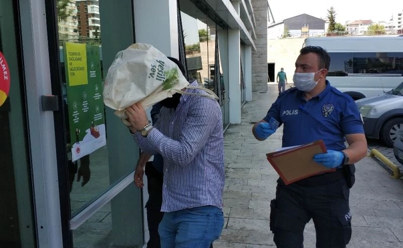 AVM’den hırsızlık zanlısı, adliyeye çıkarılırken tanınmamak için kafasına bez çanta geçirdi

