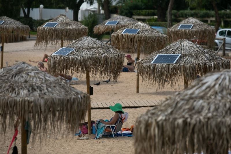 Atina plajlarında güneş enerjili telefon sarj şemsiyeleri
