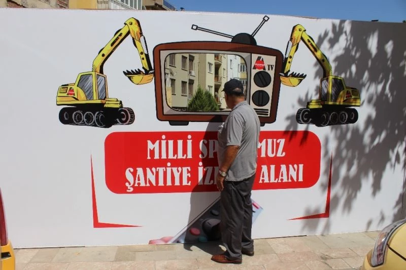 Vatandaşlar inşaat çalışmalarını televizyon şeklinde pencereden izliyor

