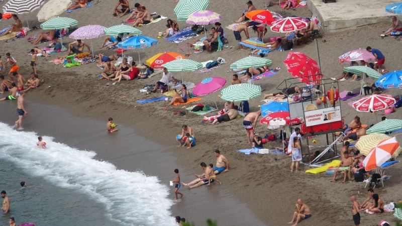 Sıcak havada plaja akın ettiler, ipte sosyal mesafeyi korudular
