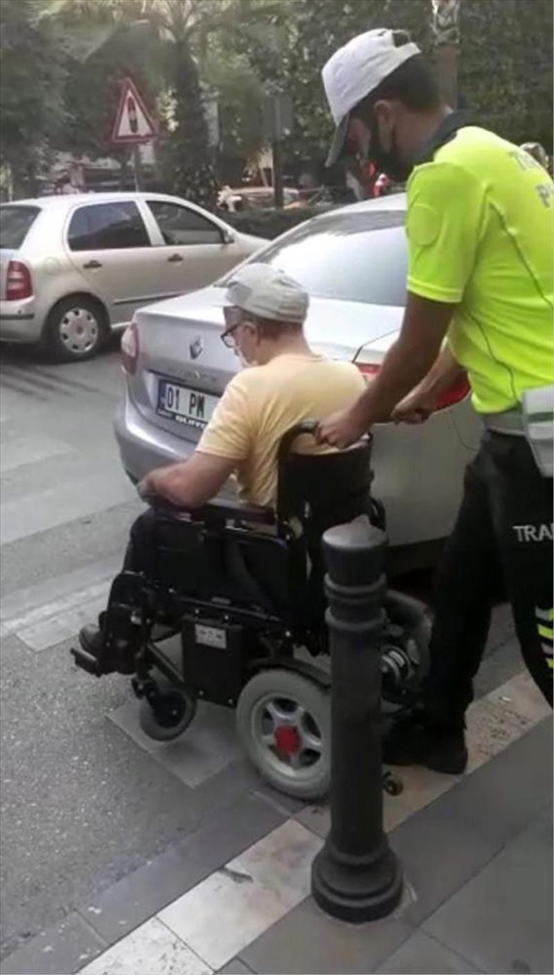 Geçide park edilen otomobil nedeniyle karşıya geçemeyen engellinin yardımına polis koştu