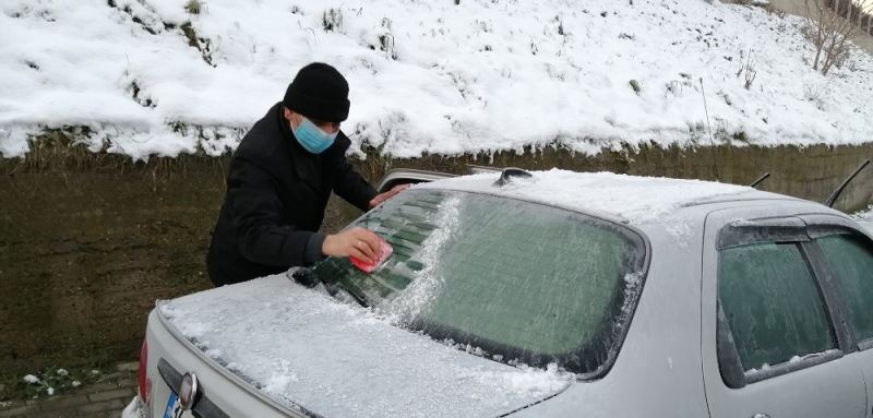 Vatandaşlar araçlarının üzerinde donan karları temizledi
