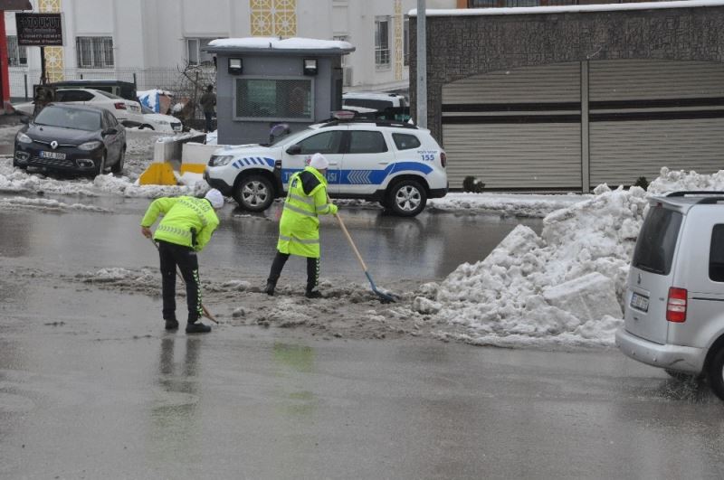 Polisler ellerine kürek aldı, yolda biriken kar birikintilerini temizledi
