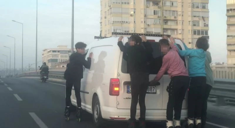 Ticari aracın arkasına yapışıp hız yapan patenciler polisi görünce çil yavrusu gibi dağıldı
