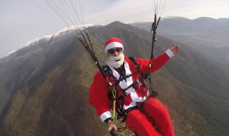 Yamaç paraşütüyle Amanoslardan atlayıp Noel baba kostümüyle hediye dağıttı