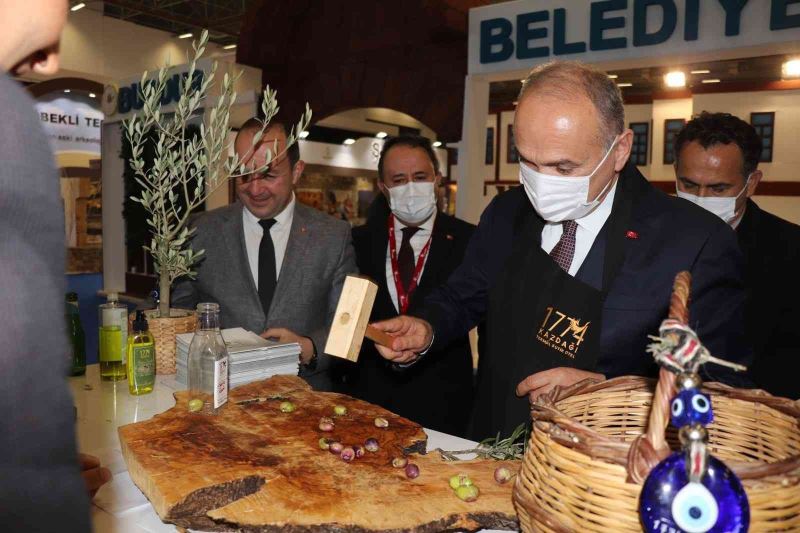 Başkan Özlü İzmir fuarında zeytin kırdı, halı dokudu
