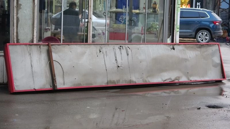 Saniyelerle düşen tabelanın altında kalmaktan kurtuldu
