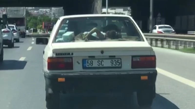 Küçük kız çocuğunu arabanın arka camına yatırdı
