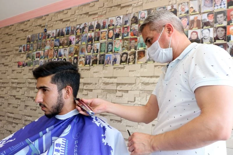 Ölen köylülerinin fotoğraflarını iş yerinin duvarında sergiliyor
