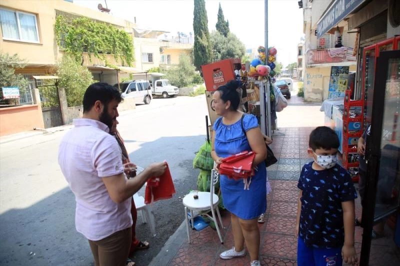 Çöpte bulduğu bayrakları temizleyip 15 Temmuz için esnafa dağıttı