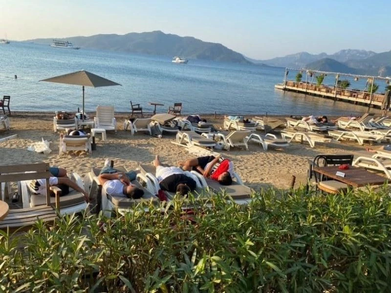 Uyarıları dikkate almayan turistler sahilde uyuyor
