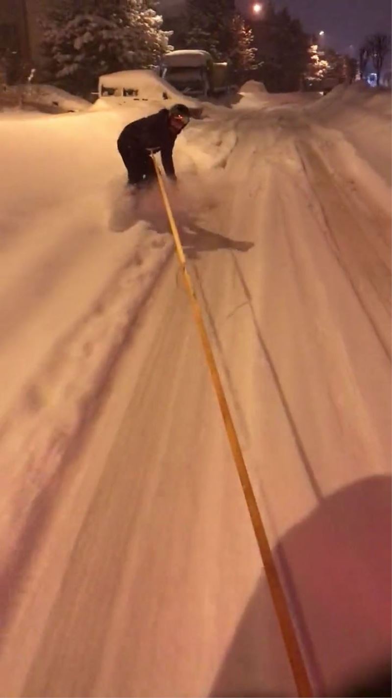 Kar keyfini sokaklarda snowboard yaparak çıkardı
