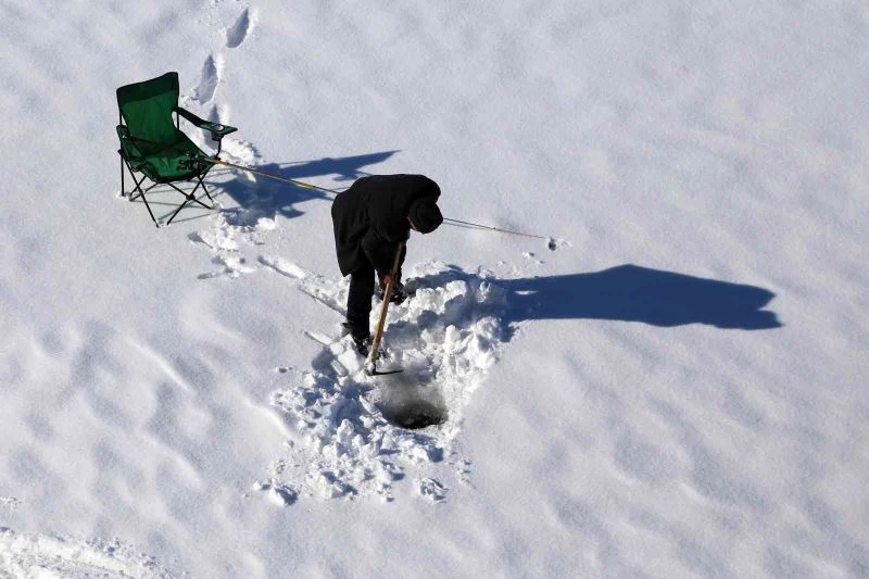 Baraj gölündeki 40 santimlik buzu kazma ile kırıp balık tutuyorlar
