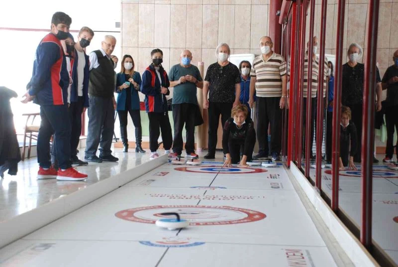 Yaşlılar ve gençlerin renkli curling müsabakası
