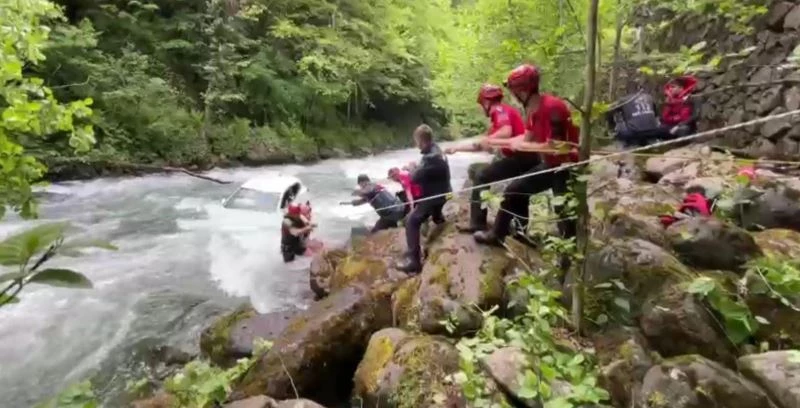 Rize’de dereye uçan aracın üzerine çıkarak yardım beklediler
