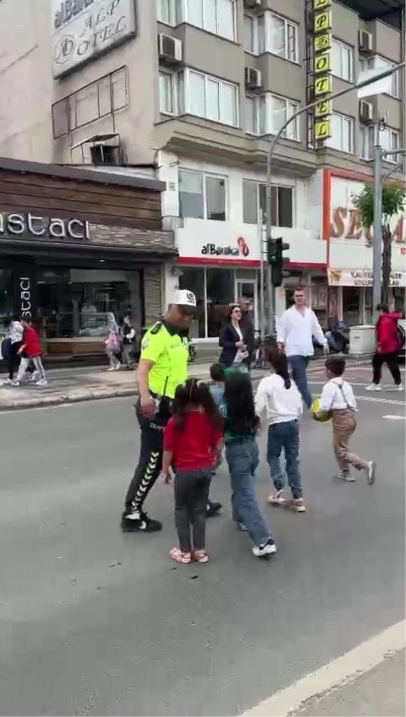 Trafik polisi trafiği kesti, çocukları karşıdan karşıya geçirdi
